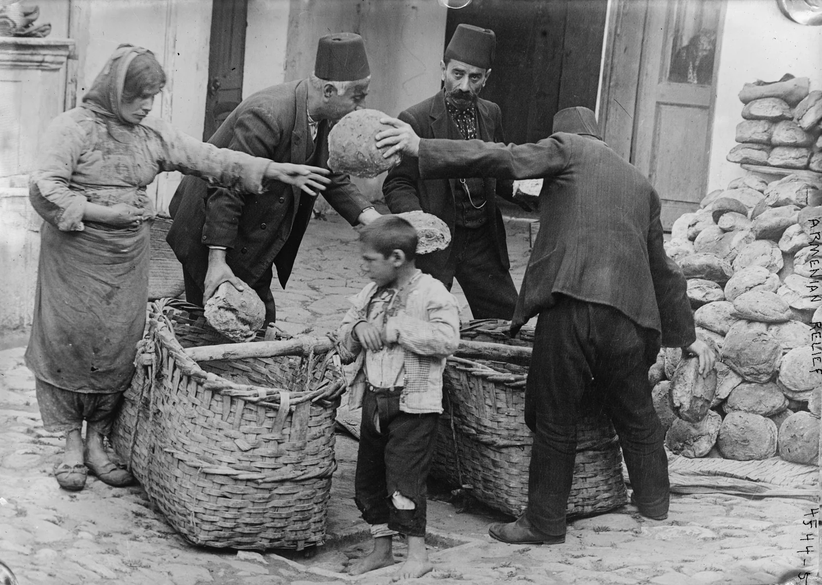 Una mujer armenia refugiada y un niño reciben alimentos. Archivo fechado entre 1915 y 1916.